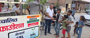 Fruits distributed to 1,800 needy children in memory of mother; inspiring message of service conveyed.